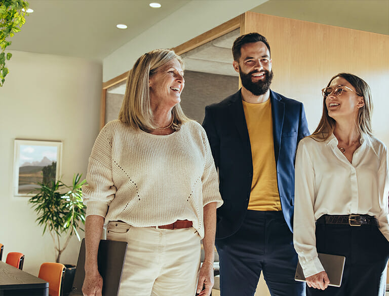 Three people standing together in an office.