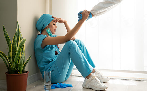 exhausted medical professional sits on the floor