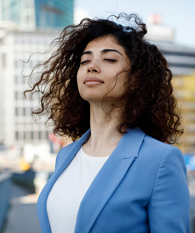 Businesswoman takes a deep breath outdoors