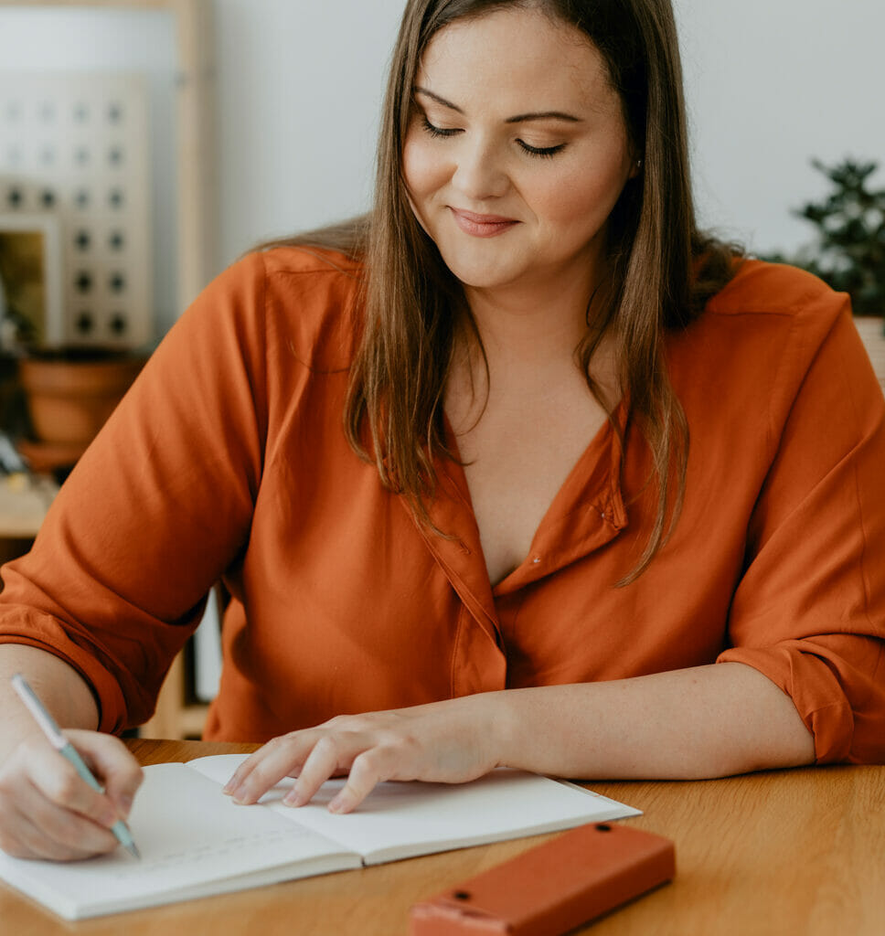 Woman sitting at her desk and writing a journal.