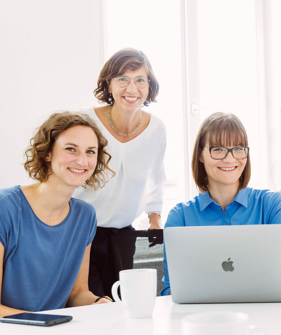 three women smile at the camera