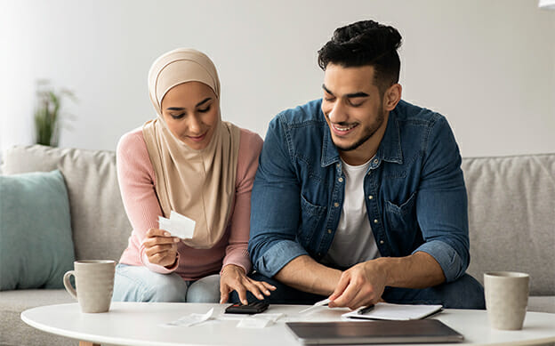 Smiling couple using calculator