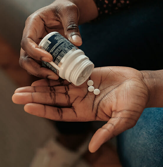 Person taking pills from a bottle