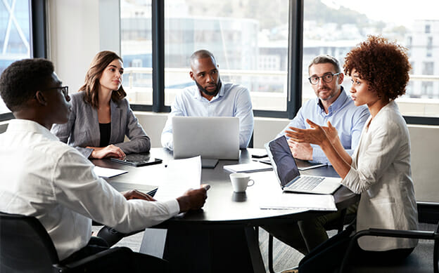 several people sitting in a team meeting