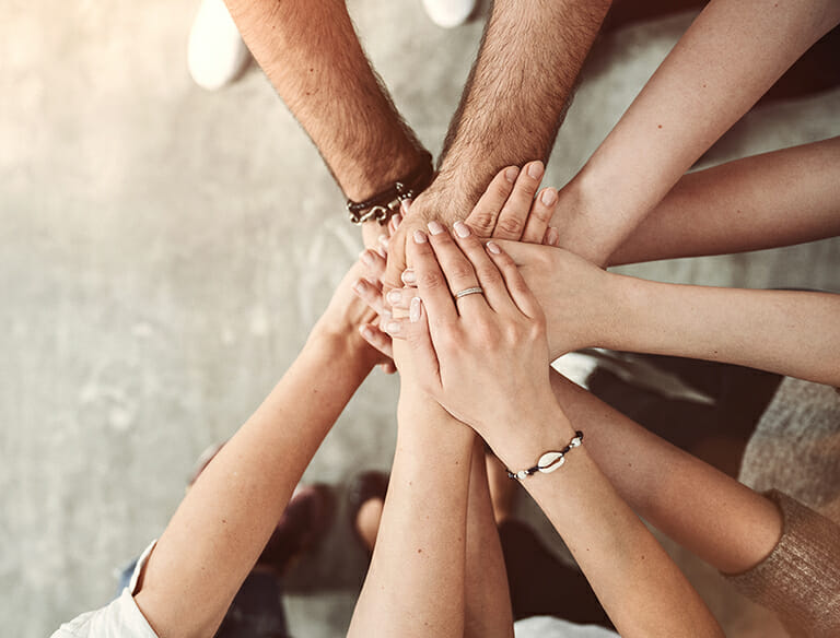 Team stacking their hands together