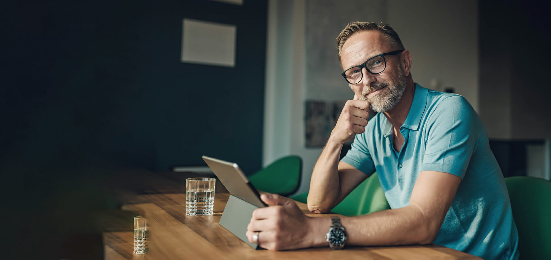 Midaged man at table with digital tablet