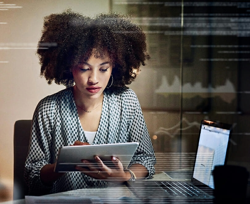 female programmer using a digital tablet while working late in her office