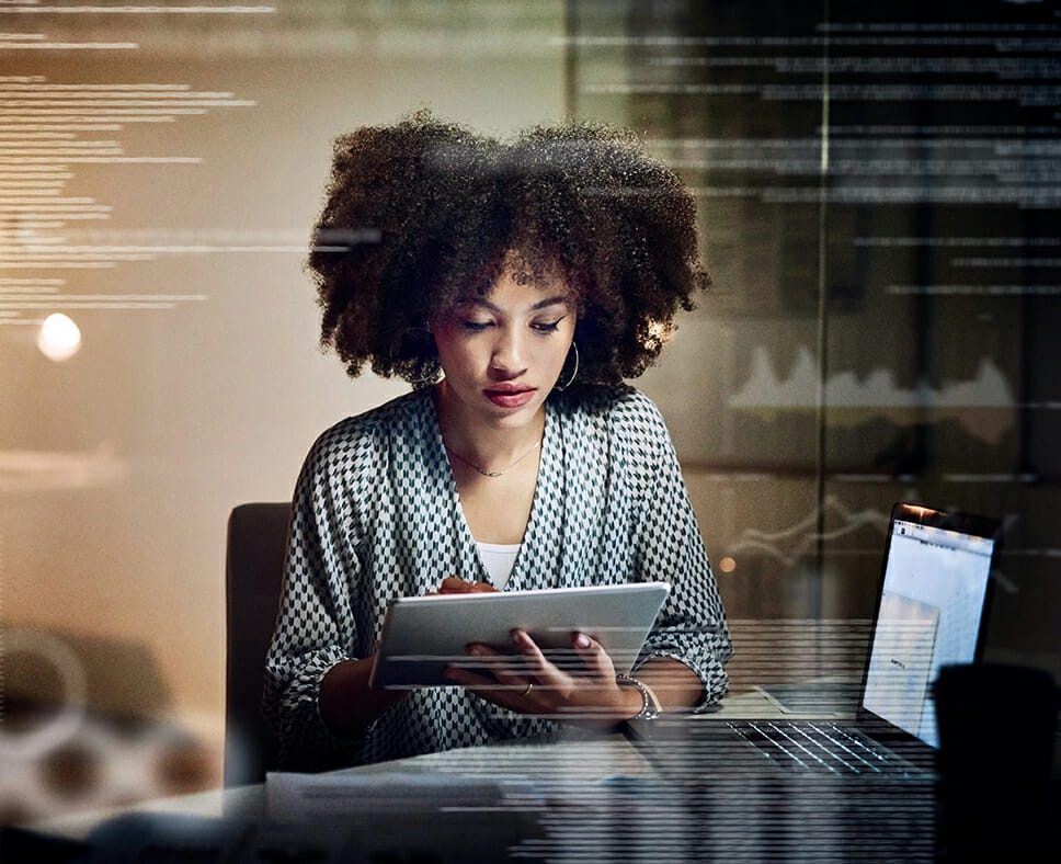 female programmer using a digital tablet while working late in her office