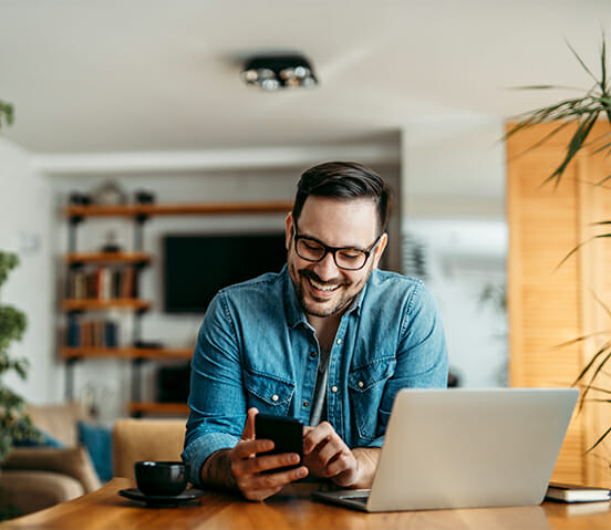 a cheerful man using smart phone at home