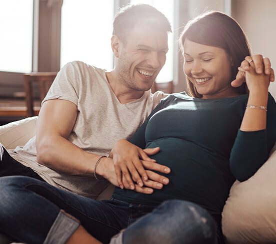 Man touches his pregnant girlfriend's belly