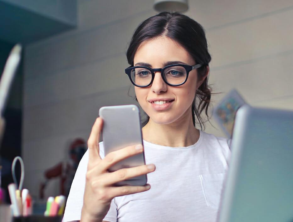 junge Frau schaut auf ihr Handy