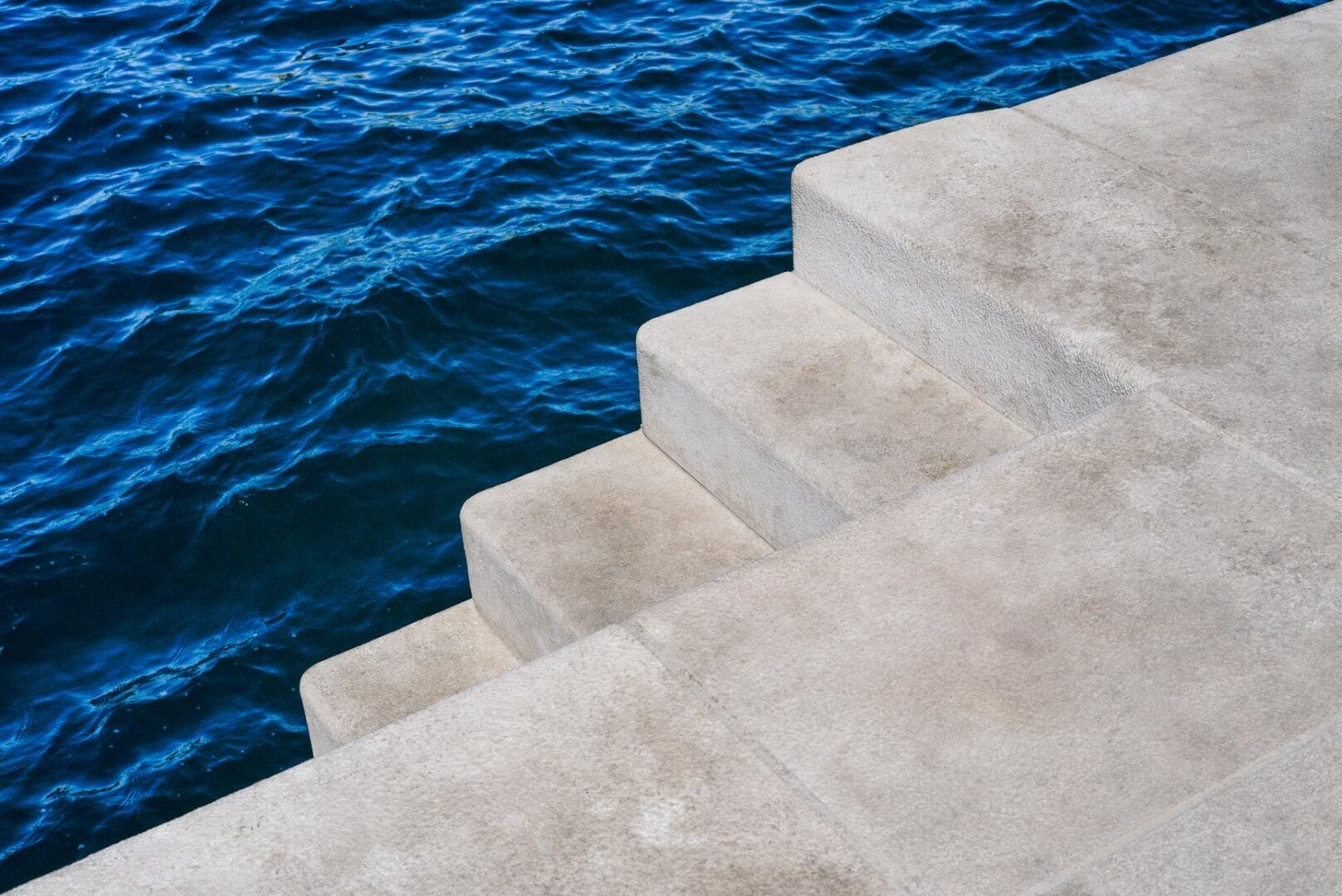 Betontreppe und dahinter blaues Meer