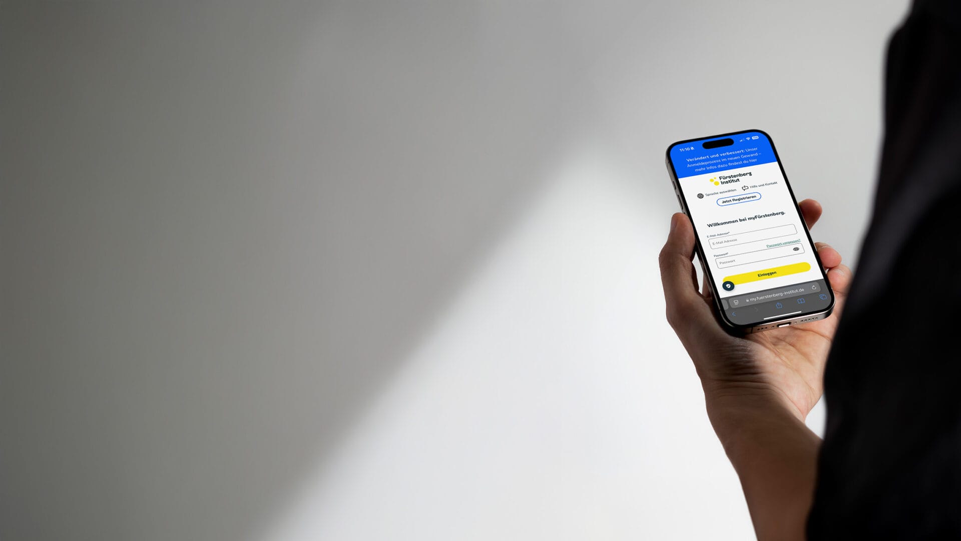 Person mit Iphone in der Hand. Auf dem Screen der Login von MyFI
