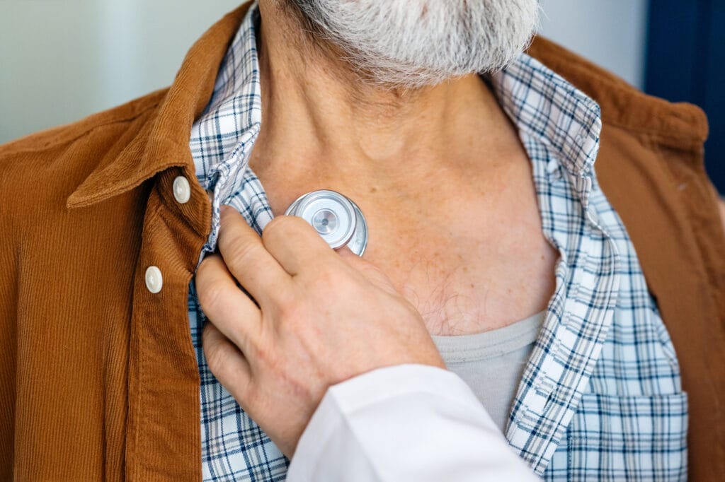 Mann wird mit Stethoskop abgehört